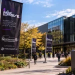 Questo luogo ospiterà, il 28 novembre 2026, la conferenza DRiVE dedicata all'accessibilità nel Sim Racing, dove 3DRap presenterà il suo Hand Controller HC1. Studenti camminano lungo il viale alberato.
